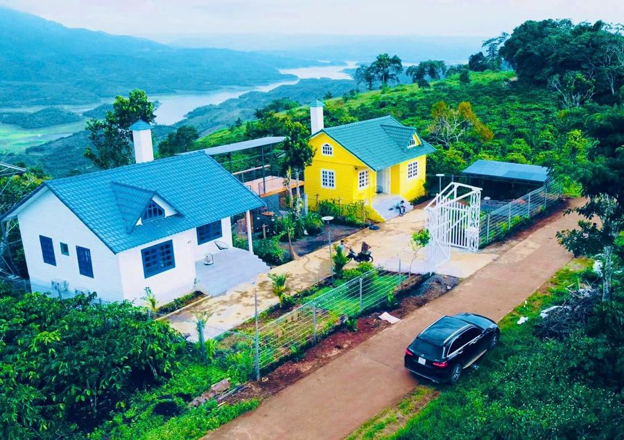Hai căn villa trắng và vàng trên đồi, xa xa là hồ Tà Đùng